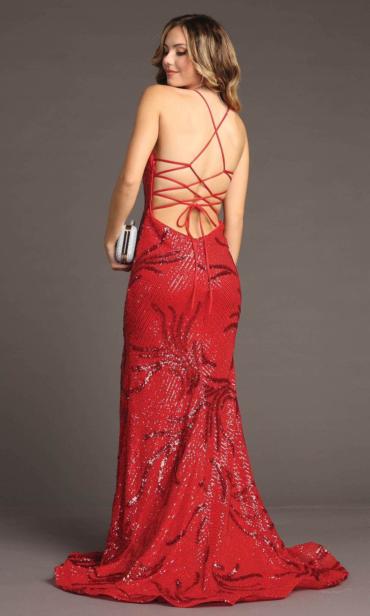Woman in a red Lace-Up Long Sequin Prom Dress: Chicas C316 with an open back, holding a silver clutch against a plain background.
